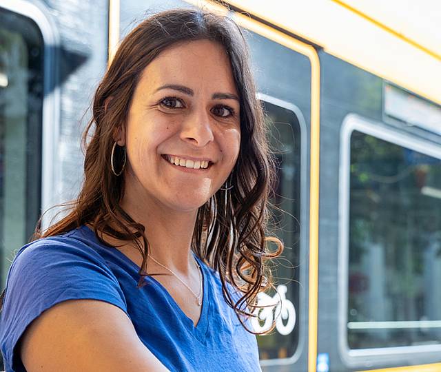 Eine Frau steht am Fahrtkartenautomat.