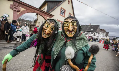 Mitglieder einer Fastnachtsgruppe ziehen als maskierte Hexen durch Hörden