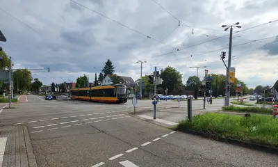 Eine Trambahn der Linie 2 passiert den Kreuzungsbereich Siemensallee/Neureuter Straße/B36. Autos stehen an Ampeln. Der Himmel ist bewölkt.