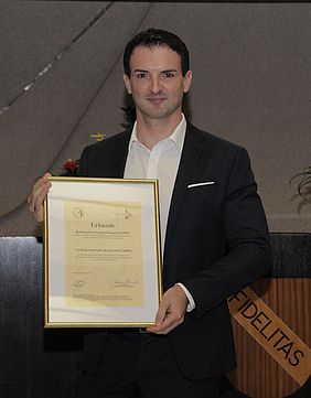 Ausbildungsleiter Stefan Mock hält Integrationspreis in der Hand.