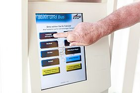Zeigefinger betätigt mobilen Fahrkartenautomat.