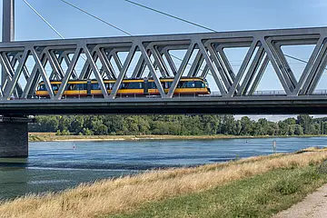 Eine AVG-Stadtbahn überquert die Rheinbrücke bei Maximiliansau.