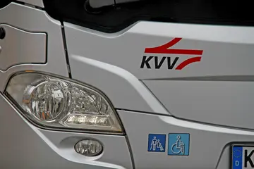 Scheinwerfer eines silbernen Bus mit dem KVV-Logo.