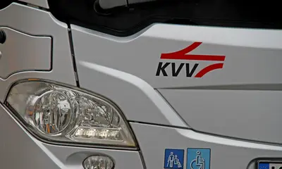 Scheinwerfer eines silberfarbenen Busses mit KVV-Logo