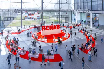 Besucher*innen bei der Messe Rehab stehen im Foyerbereich der Messe