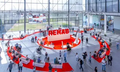Besucher*innen bei der Messe Rehab stehen im Foyerbereich der Messe