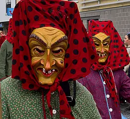 Mitglieder der Grötzinger Fastnachtsgruppe "Hottscheck"-hexen mit Häs und hölzernen Masken bei einem Fastnachtsumzug