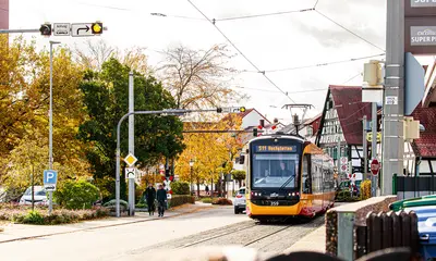 Eine Bahn der Linie S1/S11 fährt an eine Haltestelle.