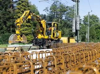 Bauarbeiten im Gleis. Ein Bagger arbeitet an einem Bahnsteig.