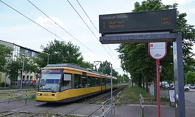 Eine Bahn der Tramlinie 4 fährt in die Haltestelle "Waldstadt Zentrum" ein.