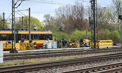 Das Foto zeigt Gleise und baumaschienen m Bereich des Bahnhofes Durlach. Eine Bahn passiert die Baustelle