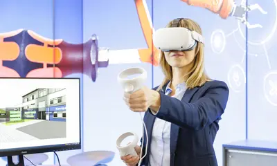Eine Frau trägt eine VR-Brille an einem Stand der Messe Learntec.