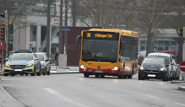 Das Foto zeigt die Buslinie 30 im Bereich des Durlacher Tors in Karlsruhe.Neben dem Bus sind ein Polizeiauto und ein PKW zu sehen. 