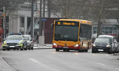 Das Foto zeigt die Buslinie 30 im Bereich des Durlacher Tors in Karlsruhe.Neben dem Bus sind ein Polizeiauto und ein PKW zu sehen.