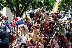 Darsteller einer Historien-Gruppe in mittelalterlichen Uniformen halten Lanzen und Fahnen.
