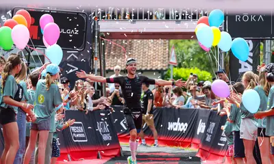 Ein Sportler überquert die Ziellinie bei einem Triathlon