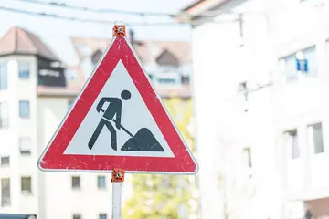 Dreieckiges Straßenschild, dass mit einem Bauarbeiter-Symbol auf Baumaßnahmen hinweist.