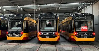 Bahnen stehen im Depot. Die Bahn links im Bild hat ein "Warnstreik"-Schild hinter der Scheibe. 