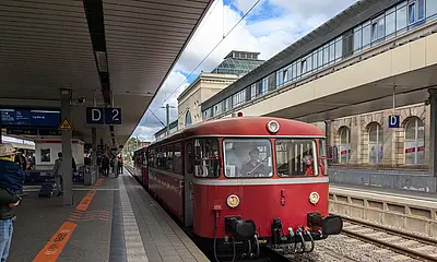 Ein historischer Schienenbus hält an einem Bahnsteig.