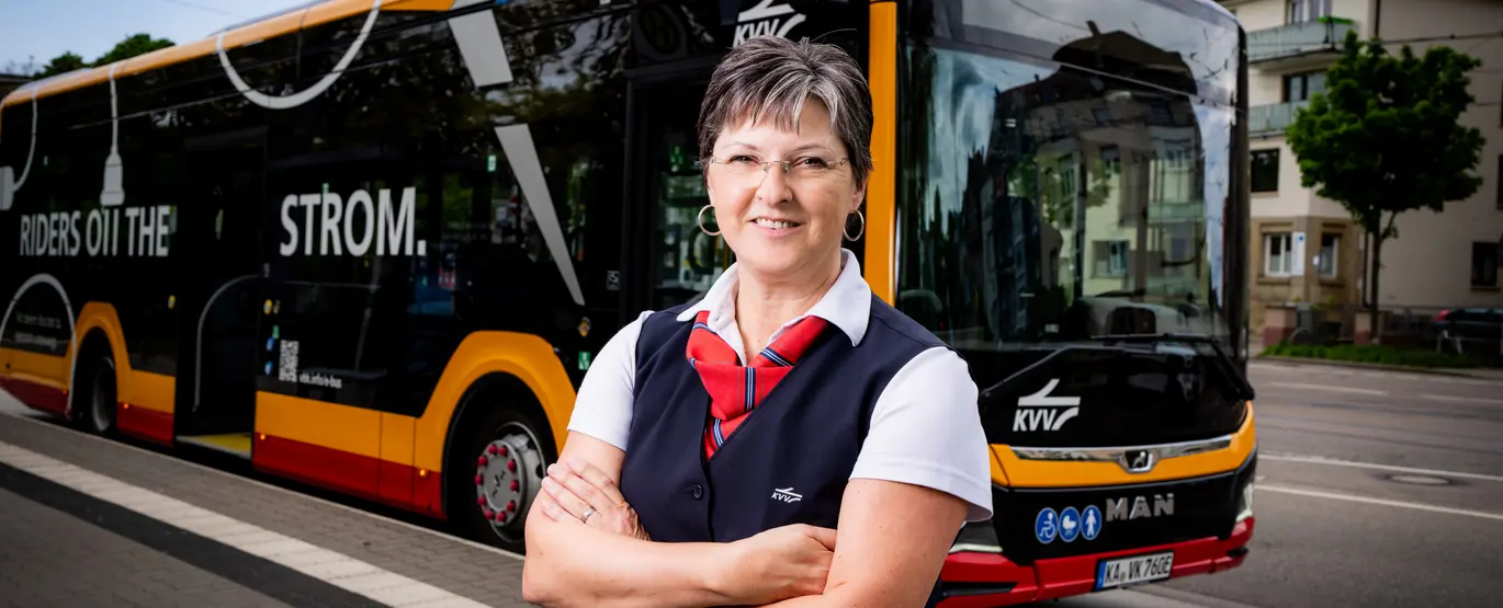 Eine Busfahrerin der VBK steht vor dem modernen Elektrobus.