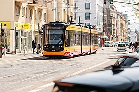 Gelb-rote Straßenbahn in der Karlsruher Karlstraße vor einer Häuserzeile