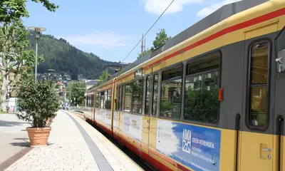 Eine AVG-Stadtbahn der Linie S6 hält an einem Bahnsteig in der Innnenstadt von Bad Wildbad.