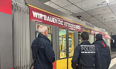 Polizei und BIG-Fahrscheinprüfer stehen vor einer VBK-Tram im Stadtbahntunnel.