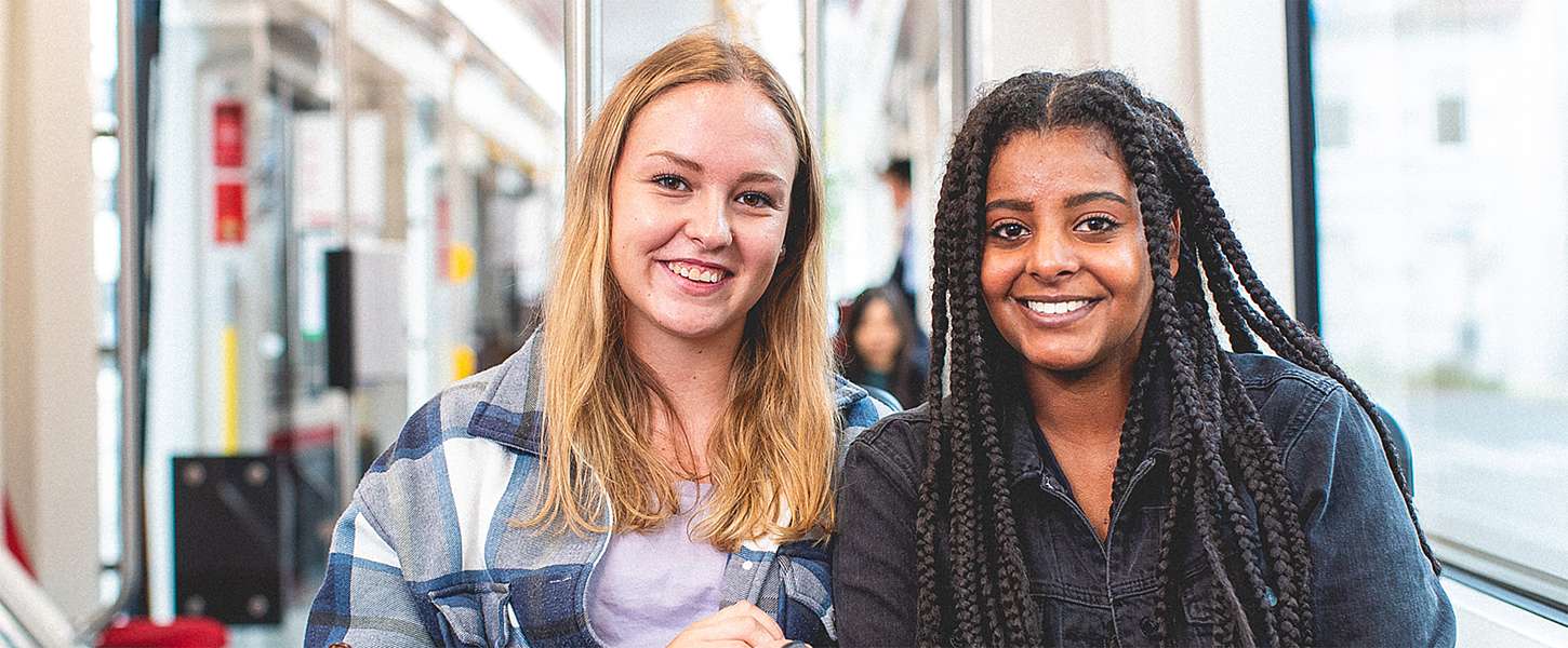 Zwei junge Teenager-Mädchen sitzen in der Bahn.