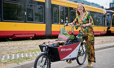 Eine Frau steht neben einem Lastenfahrrad.
