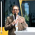 Der technische Geschäftsführer Christian Höglmeier steht vor einer Stadtbahn und spricht in ein Mikrofon.
