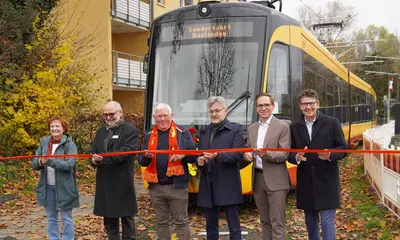 Das Foto zeigt den symbolischen Banddurchschnitt zur Eröffnung der modernisierten Bahnstrecke in Daxlanden. Dahinter steht eine Trambahn.Die abgebildeten Personen sind von links nach rechts Nach den intensiven Bauarbeiten der vergangenen Monate wurde heute die modernisierte Bahnstrecke in Daxlanden feierlich eröffnet. Über die Wiederaufnahme des Bahnbetriebs bei der Tramlinie 3 freuen sich beim symbolischen Banddurchschnitt (von links nach rechts) Karin Armbruster (1. Vorsitzende Bürgerverein Grünwinkel), Andreas Huber und Horst Kappler (Vor-stand Bürgerverein Daxlanden), Dr. Frank Mentrup (Oberbürgermeister der Stadt Karlsruhe), Christian Höglmeier (technischer Geschäftsführer der VBK) und Prof. Dr. Alexander Pischon (Geschäftsführer der VBK). 