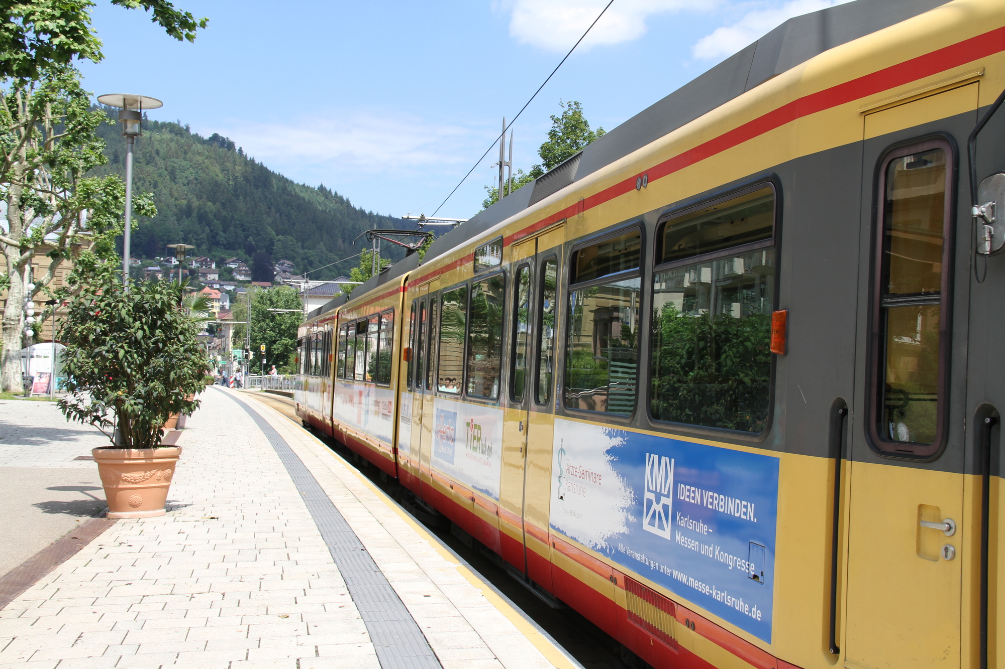 Eine AVG-Stadtbahn der Linie S6 hält an einem Bahnsteig in der Innnenstadt von Bad Wildbad.