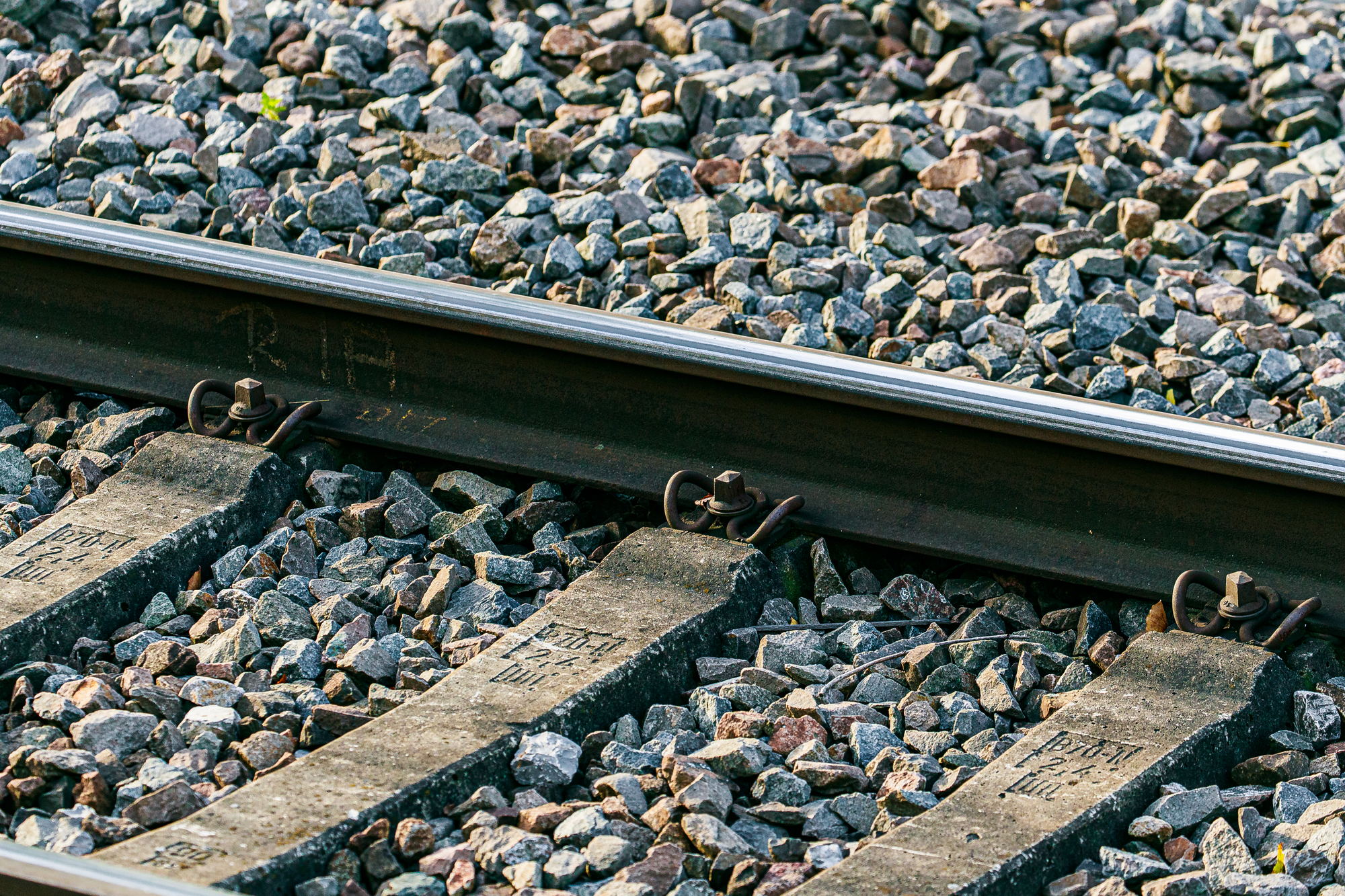 Schienen und Gleisschwellen auf einem geschotterten Bahnkörper