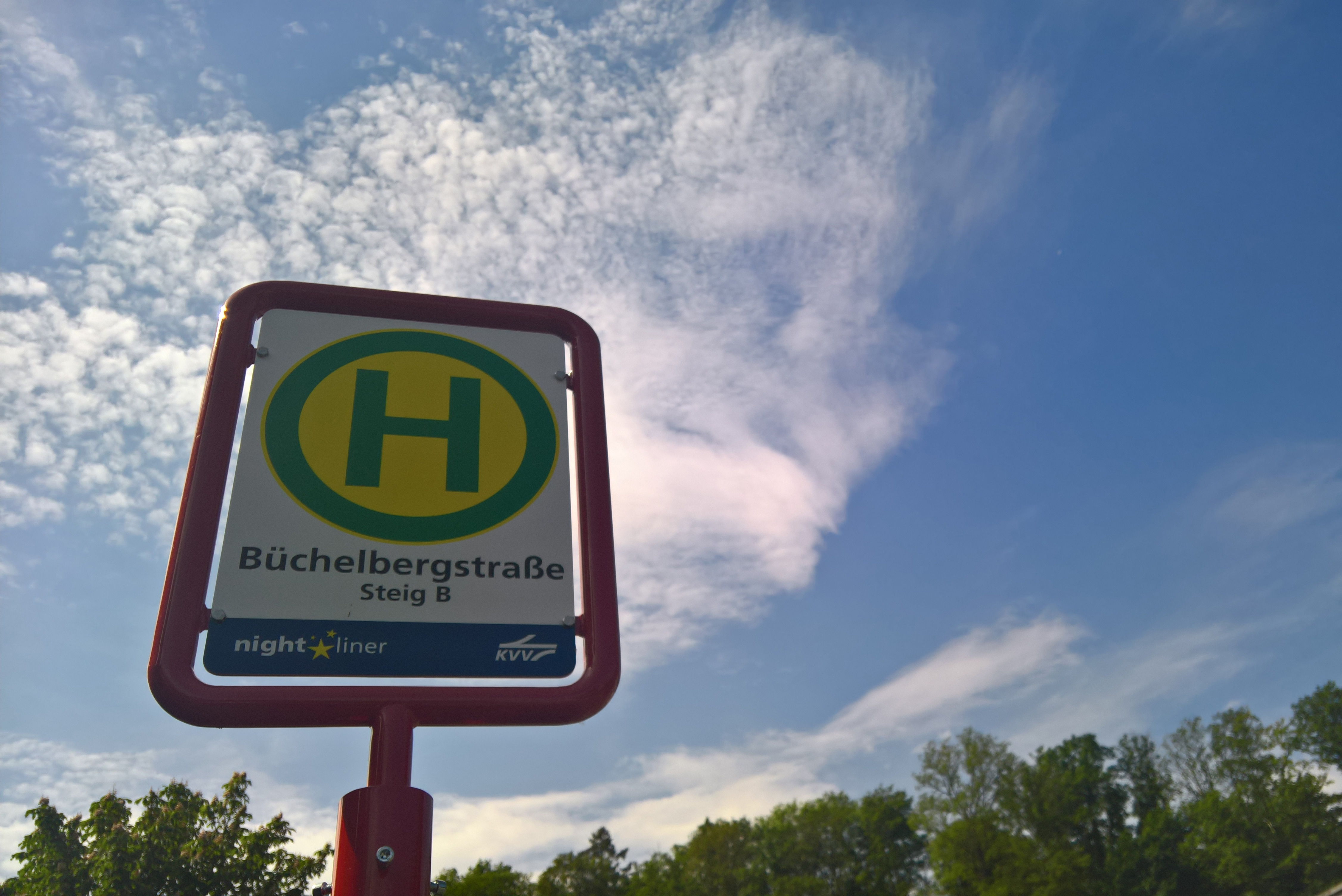 Haltestellen-Schild in der Büchelbergstraße in Grötzingen vor leicht bewölktem, blauem Himmel