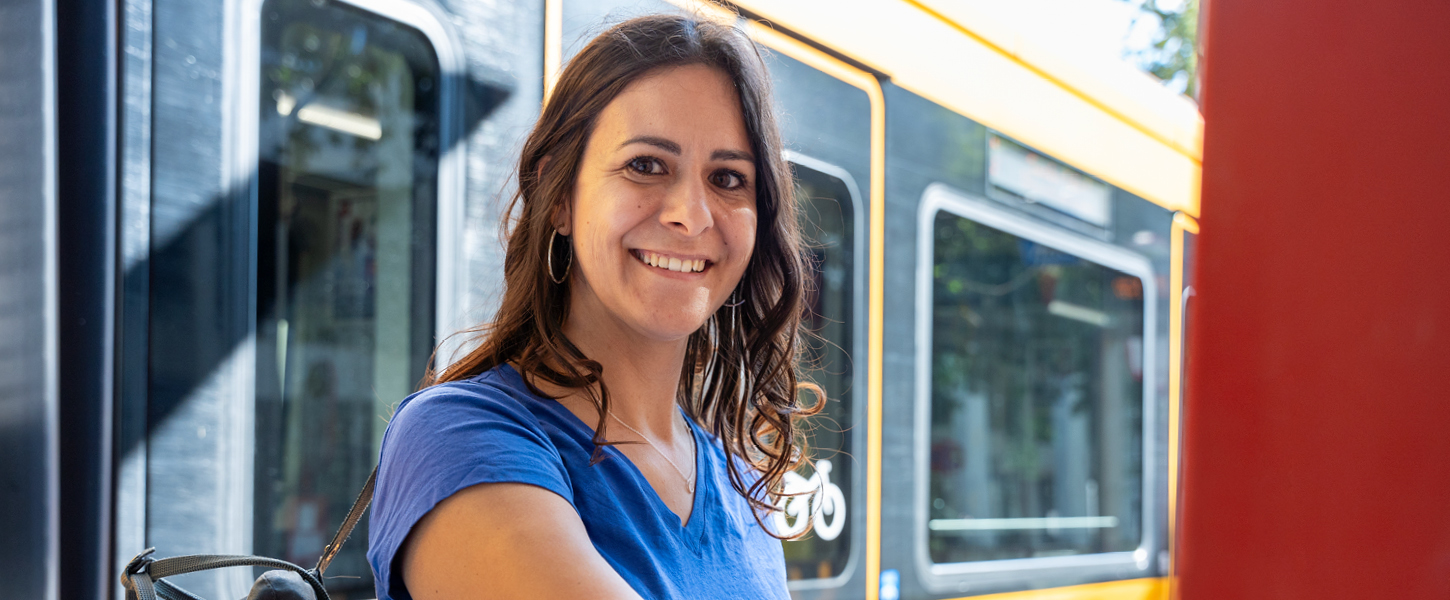 Eine Frau steht am Fahrtkartenautomat.